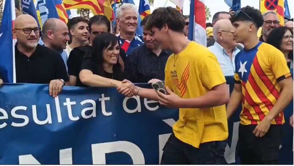 Sílvia Orriols saludant un jove amb samarreta de l'ANC durant la Diada.